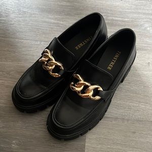 chunky black loafers with gold chain